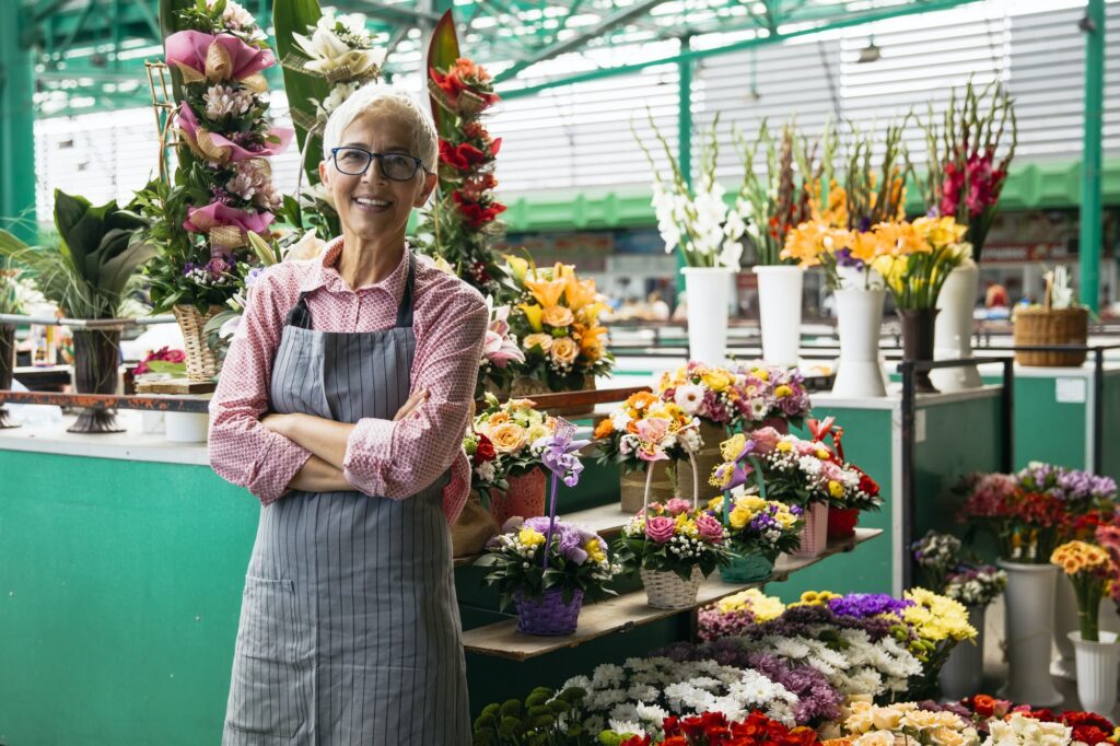 Portrait of senior woman sales flowers on local flower market